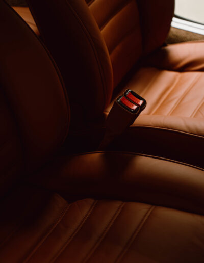 Tan leather seat and red seat-belt buckle