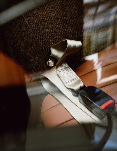 Seat-belt fittings beside tan interior upholstery