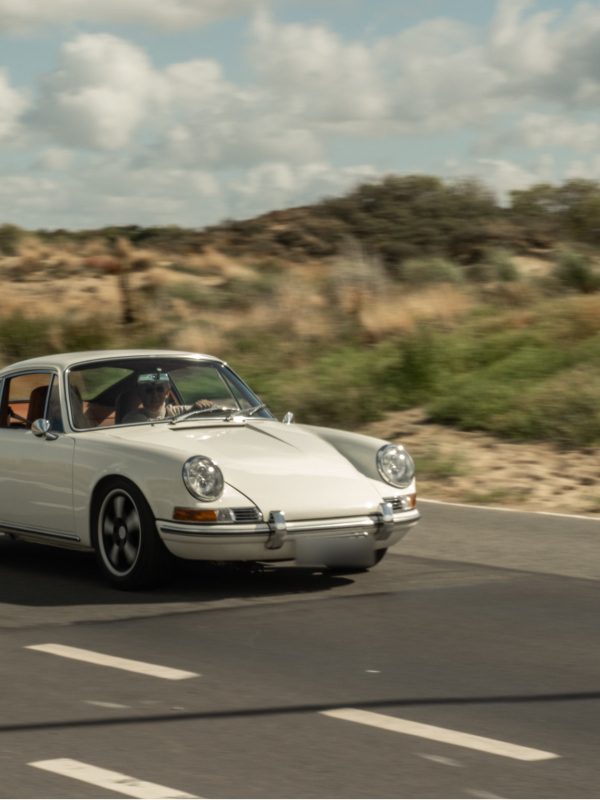 White Revolt Electric driving along a road beside sand dunes